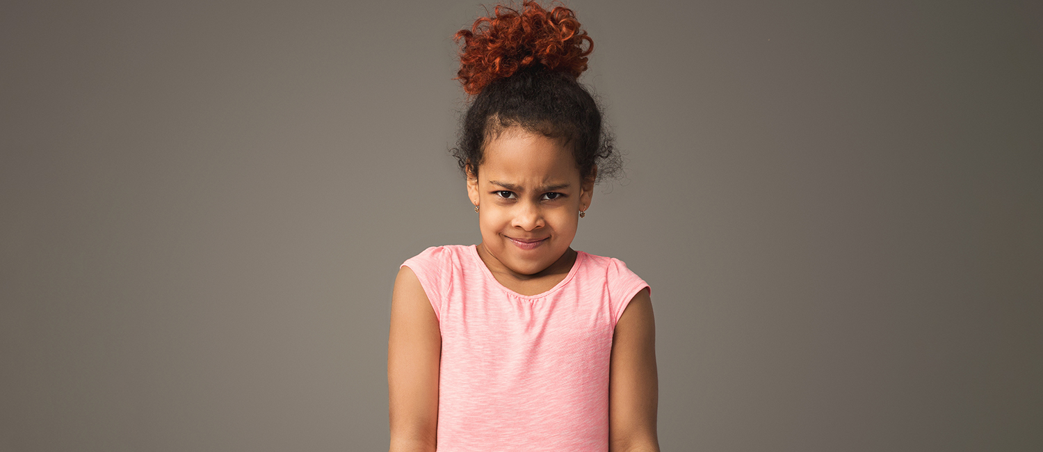  Young girl in pink shirt looking frustrated because her parents aren't solve her problems. 