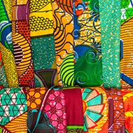 pile of folded brightly-colored textiles 
