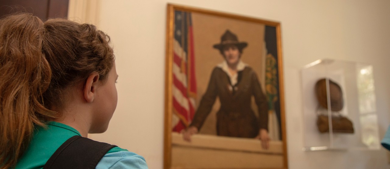 Girl Scout looking at a picture of Juliette Gordon Low in the Juliette Gordon Low Birthplace