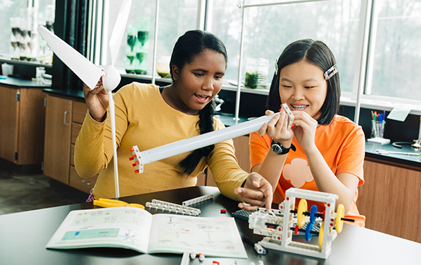 dos niñas construyendo una turbina eólica